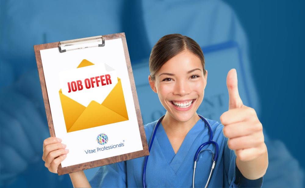 Profissional sorridente a analisar oferta de trabalho internacional com a ajuda da Vitae Professionals.